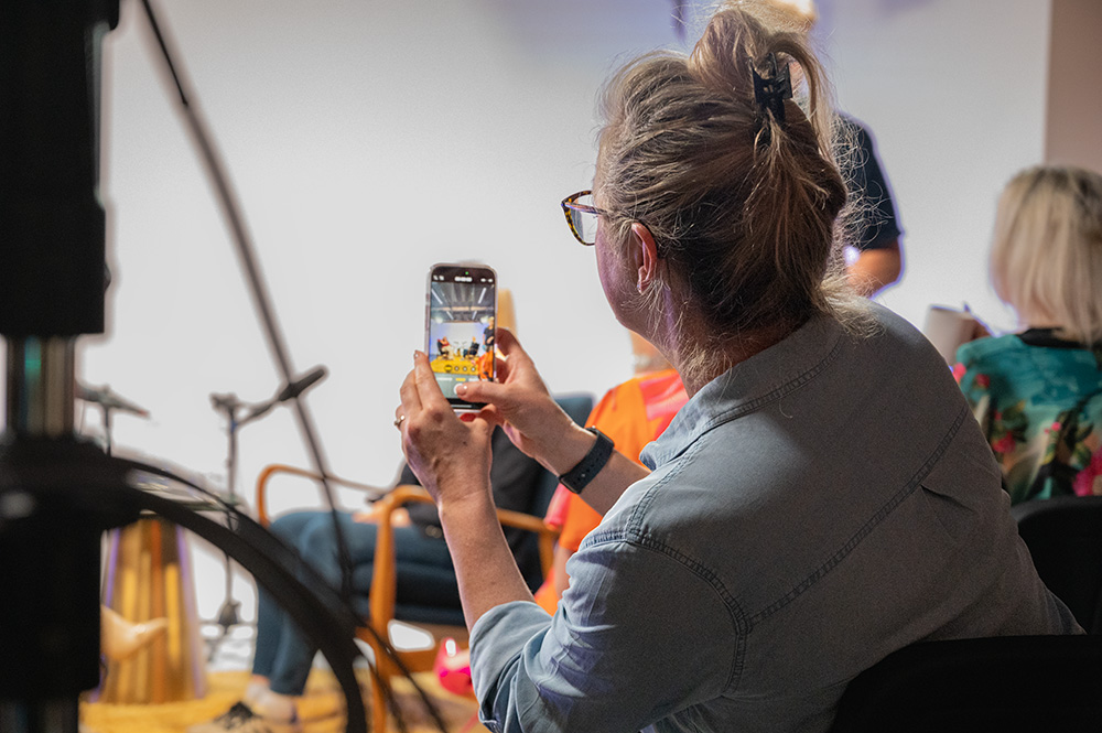 An attendee capturing the live recording on her phone